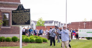 A School 26 alum stands in front of the newly unveiled historical marker honoring John Hope School 26 and the Paul Laurence Dunbar Library